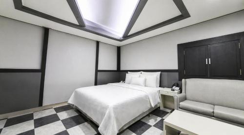 a bedroom with a large bed and a skylight at Hive Hotel in Tongduch'ŏn
