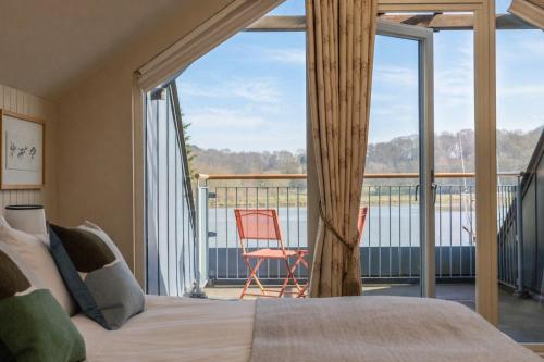 a bedroom with a bed and a balcony with a view at The Crow's Nest in Woodbridge