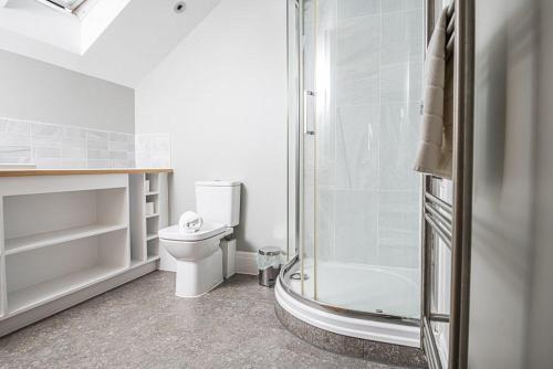 a white bathroom with a shower and a toilet at The Crow's Nest in Woodbridge