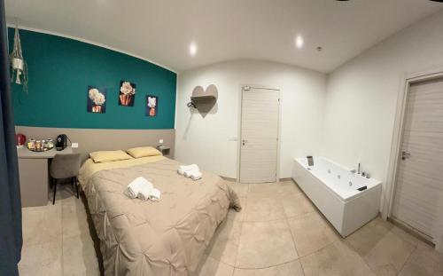 a bedroom with a large bed and a bath tub at Residenza De Rose 2 in Cosenza
