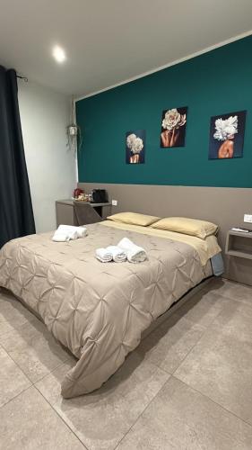 a bedroom with a large bed with two towels on it at Residenza De Rose 2 in Cosenza