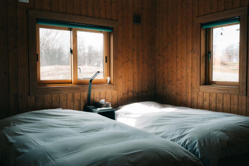 a bedroom with a bed and two windows at Lakeview Etsu in Lake Toya