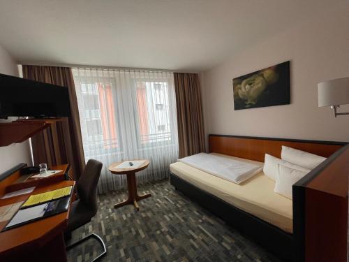 a hotel room with a bed and a table at Advantage Appartements Hotel in Nuremberg