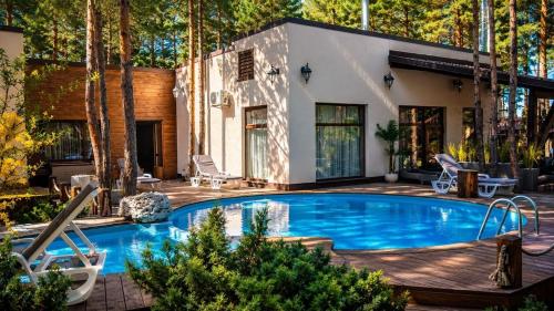 a swimming pool in a backyard with a house at Дом в лесу 1dom club in Protsev