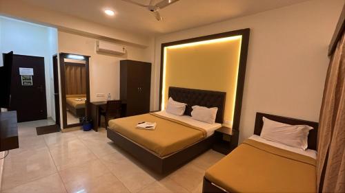 a hotel room with two beds and a mirror at Jerry's Chateau in Pondicherry
