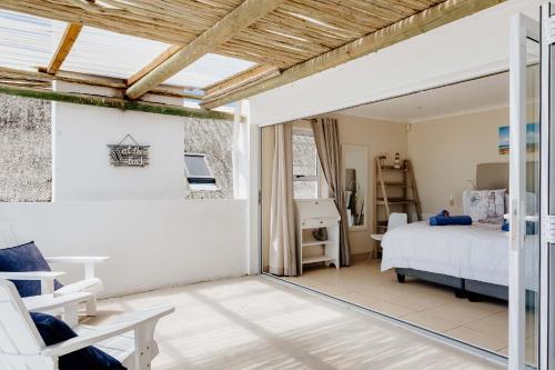 a bedroom with a bed and a table and chairs at Sterretjie in Paternoster
