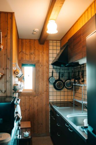 a kitchen with wooden walls and a sink and a window at Lakeview Etsu in Lake Toya