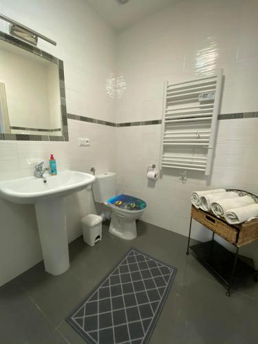 a white bathroom with a sink and a toilet at Hotel Koruna penzion in Teplice nad Metují