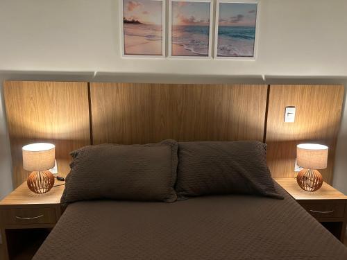 a bedroom with a bed with two lamps on it at Apartamento luxo próximo Alphaville com vaga -5 min estação trem -ótima localização in Osasco