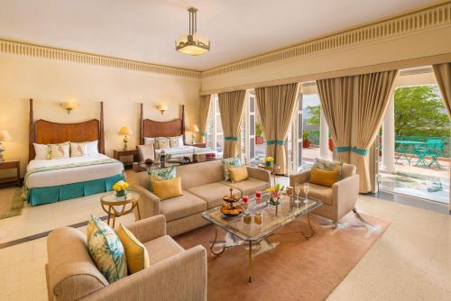 a hotel room with a bed and a living room at Ramgarh Lodge, Jaipur – IHCL SeleQtions in Jaipur