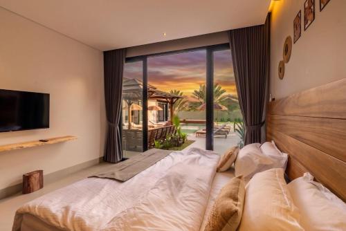 a bedroom with a bed and a large window at The Reef Villa in Bahlāʼ