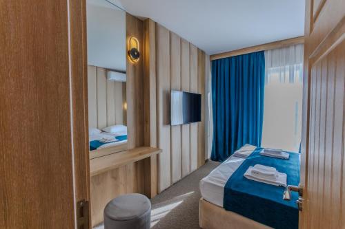 a hotel room with a bed and a television at Family Hotel Deja Vu in Ravda