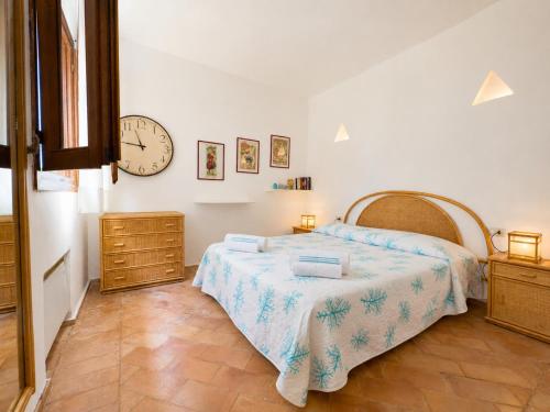 a bedroom with a bed and a clock on the wall at Alba Ruja Residence 2 with Pool Close to All Amenities in Porto Cervo