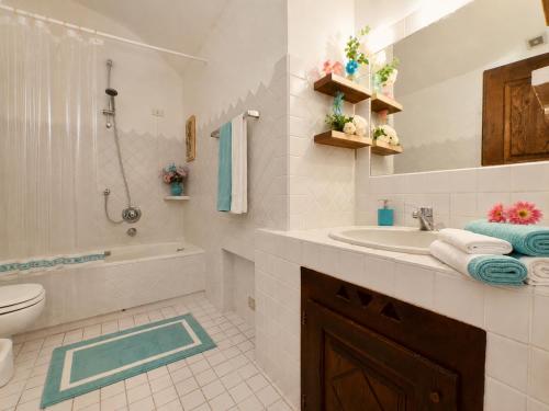 a white bathroom with a sink and a toilet at Alba Ruja Residence 2 with Pool Close to All Amenities in Porto Cervo