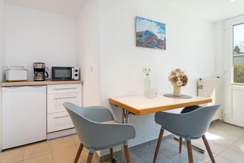 a kitchen with a wooden table and chairs at Alte Dorfstraße 29 REETungsinsel in Behrensdorf