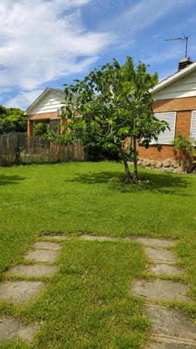 a tree in a yard next to a house at Villa Lorelia in La Adrada