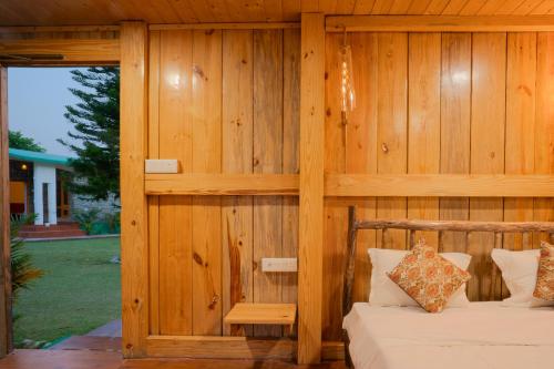 a room with a bed and a wooden wall at Wildernest Resort in Kota Bāgh