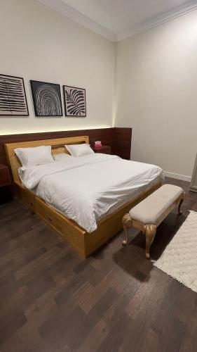 a bedroom with a large bed and a bench at اليمامه in Al Yamāmah