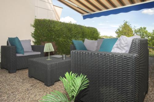 a patio with two wicker chairs and a table at L'Orée in Turckheim