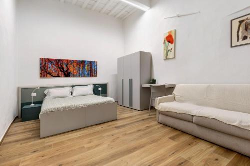 a bedroom with a bed and a couch and a desk at Ser Lapo - Dimora storica a Prato in Prato