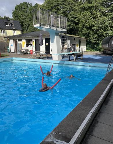 three people in a swimming pool in the water at Bra familjeboende Vitaby in Vitaby