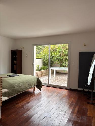 a bedroom with a bed and a sliding glass door at La Maison des Eléphants in Vivonne
