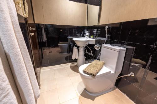 a bathroom with a toilet and a sink at AL Muahidb Residence Al Takhasossi 5 - Economic in Riyadh