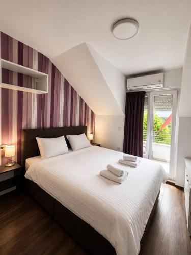 a bedroom with a large bed with two towels on it at VilaMihaela in Skopje