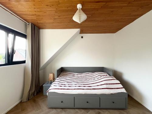 a bedroom with a bed with a wooden ceiling at PS Casa in Hasselt
