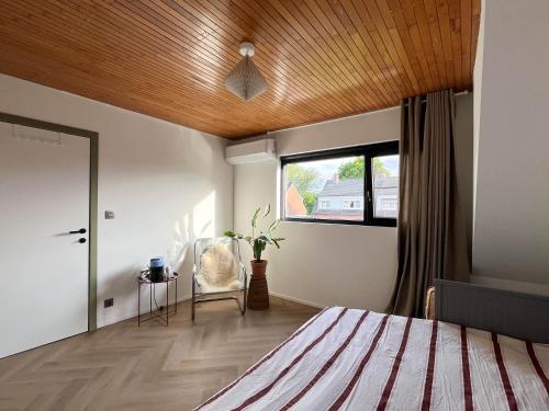 a bedroom with a bed with a wooden ceiling at PS Casa in Hasselt