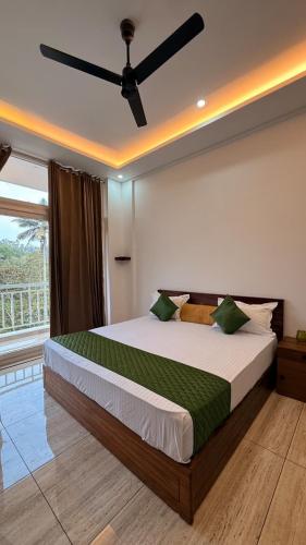 a bedroom with a large bed with a ceiling fan at Uforia Munnar in Munnar