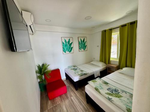 a room with two beds and a flat screen tv at Sea Breeze inn in Providencia