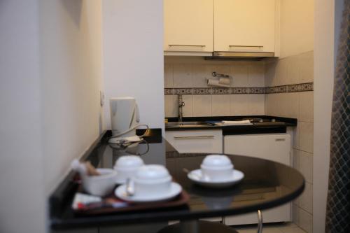 una pequeña cocina con una mesa con platos. en King Hotel Guvenlik, en Ankara