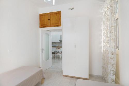 a white room with a bed and a cabinet at Angel's House in Sarno