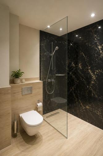 a bathroom with a toilet and a glass shower at Hotel Night4Flight Hamburg-Airport in Hamburg
