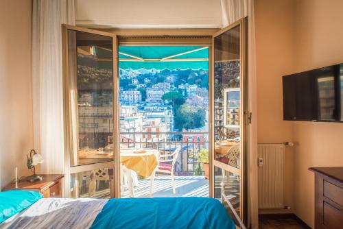 a bedroom with a view of a city from a balcony at MARI E MONTI Appartamento centrale con vista panoramica in Rapallo