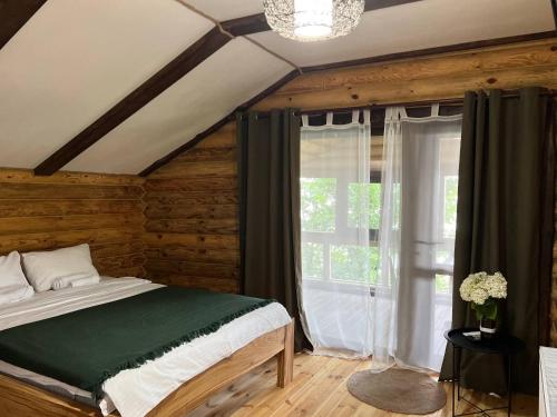 a bedroom with a bed and a large window at Наше Місце in Krymno