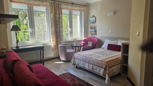 a bedroom with a bed and a couch and windows at Comfort Willa in Jurata