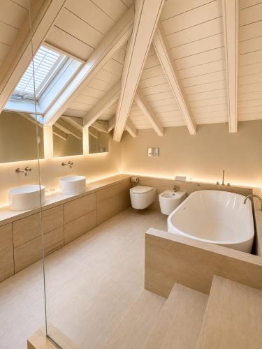 a bathroom with two sinks and a tub and two toilets at Hotel Carducci 76 in Cattolica