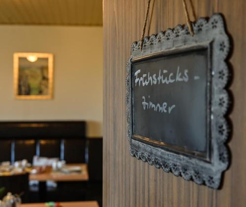 a chalkboard sign on a wall in a restaurant at Pension Schöpke in Bad Staffelstein