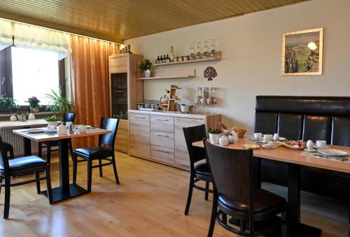a kitchen and dining room with tables and chairs at Pension Schöpke in Bad Staffelstein