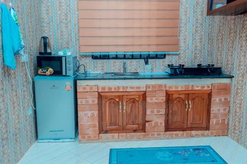 a kitchen with a brick counter and a blue refrigerator at Kamur Homes Apartment in Dodoma