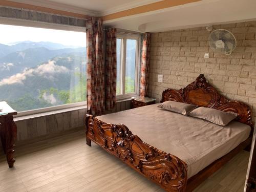 a bedroom with a large bed and a large window at Swami Manjulanand Ashram in Mohan Chatti