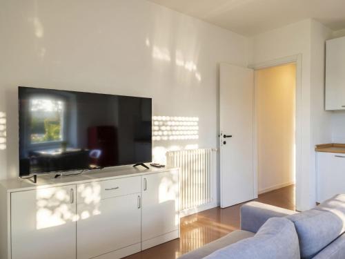 a living room with a couch and a flat screen tv at Apartment Tinca by Interhome in Domaso