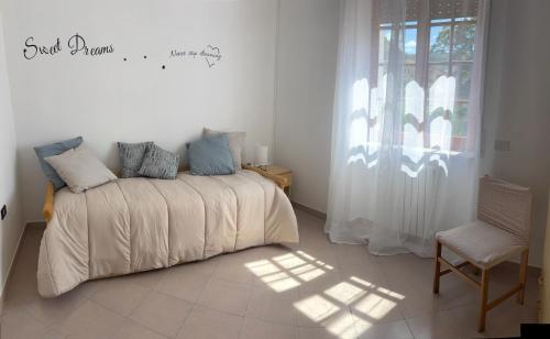 a bedroom with a bed and a chair and a window at Villa Filomena in Montoro Inferiore