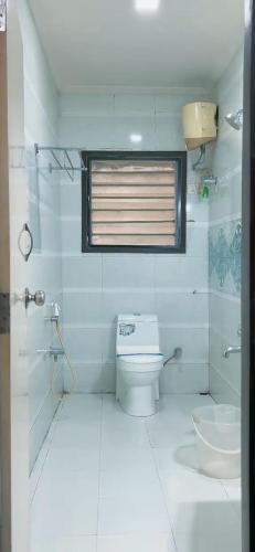 a white bathroom with a toilet and a sink at Hotel Gazala in Palakkad
