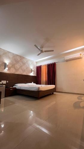 a bedroom with a bed and a ceiling fan at Hotel Gazala in Palakkad