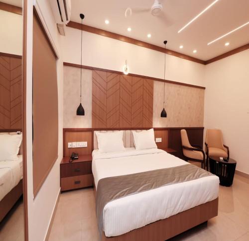 a bedroom with a large bed and a chair at AdaraResidency in Trivandrum