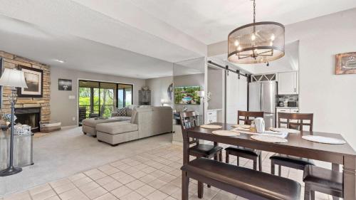 a kitchen and living room with a table and chairs at Lake Ozark Oasis Central Location & Pool Access in Lake Ozark