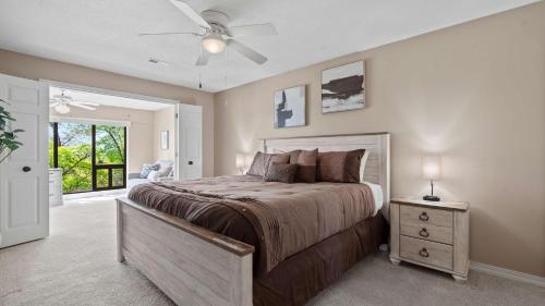 a bedroom with a large bed and a ceiling fan at Lake Ozark Oasis Central Location & Pool Access in Lake Ozark